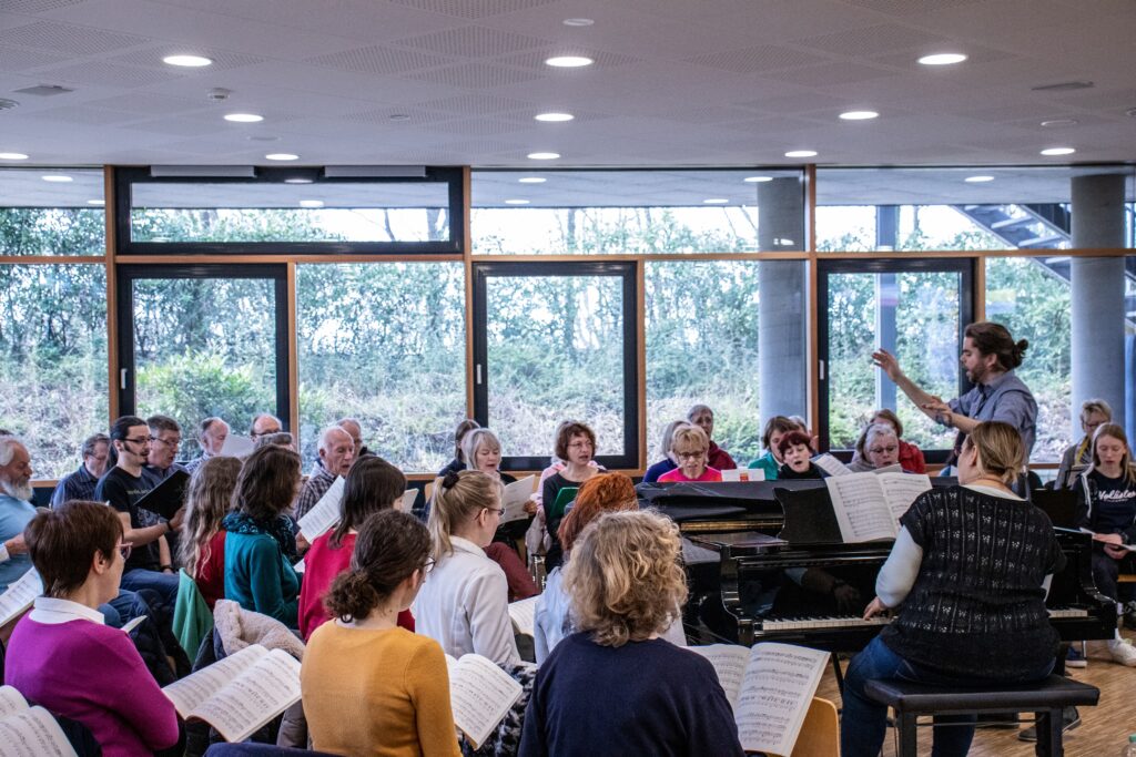 David Brost leitet die Probe des Projektchors, während Franziska Wagner-Lutz den Projektchor am Klavier korrepetiert.